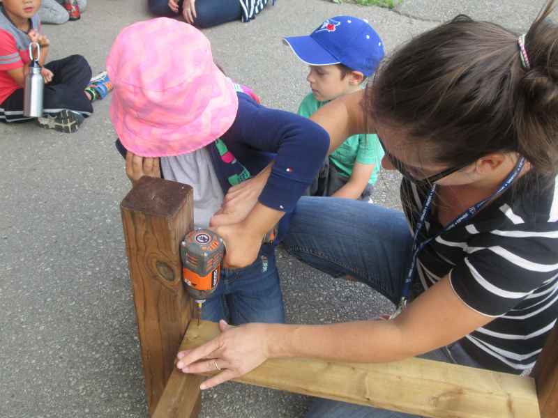 children using a drill to build their bridge